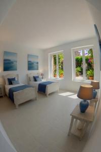 a large white room with two beds and windows at Home Mykonos lux in Casoria