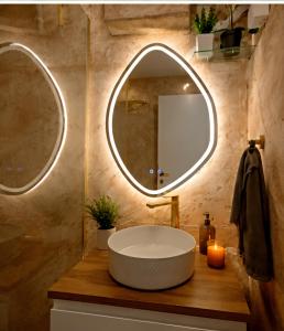 a bathroom with a large tub and a round mirror at Casa de Flores in Knjazevac.