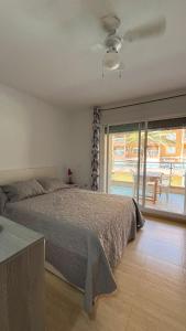 a bedroom with a bed and a view of a patio at Roquetas "Estudio acogedor cerca del Castillo y del puerto de Roquetas, aireconditionado" in Roquetas de Mar