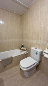 a bathroom with a toilet and a bath tub at Roquetas "Estudio acogedor cerca del Castillo y del puerto de Roquetas, aireconditionado" in Roquetas de Mar +23 photos