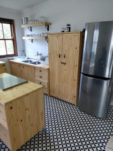 a kitchen with wooden cabinets and a stainless steel refrigerator at The Galleons in Barrydale