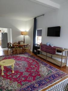a living room with a table and a rug at The Galleons in Barrydale