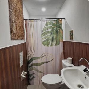 ein Badezimmer mit Toilette und Duschvorhang in der Unterkunft The Zion Bedspace- Olongapo City in Olongapo