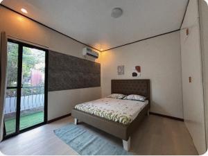 ein Schlafzimmer mit einem Bett und einem großen Fenster in der Unterkunft The Zion Bedspace- Olongapo City in Olongapo