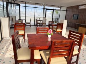 a dining room with a wooden table and chairs at Hotel V Stay in Chennai