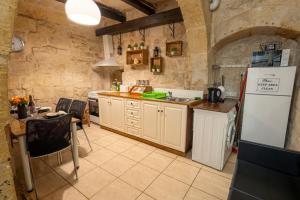 a kitchen with a refrigerator and a table in a room at 3Cities Maison close to Valletta in Cospicua