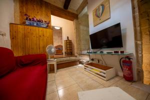 a living room with a couch and a flat screen tv at 3Cities Maison close to Valletta in Cospicua