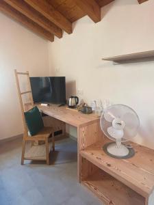 a wooden desk with a fan and a computer monitor at Mondo D'Oro in Macugnaga
