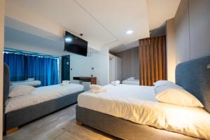a hotel room with two beds and a television at COLFA STAR Hostel in Bejaïa +42 photos