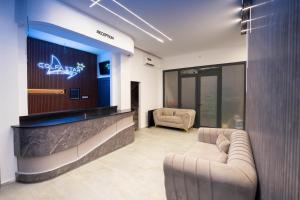 a lobby with two couches and a sign on a wall at COLFA STAR Hostel in Bejaïa