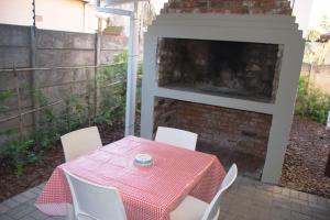 a table and chairs on a patio with a fireplace at Tooiselvere in George