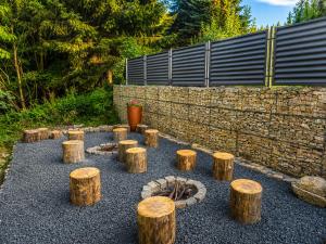 a group of logs and a fire place in a garden at Apartmány Plavy - Jizerské hory in Plavy