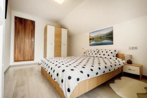 a bedroom with a bed with a black and white comforter at Casa Sofisa in Fundata