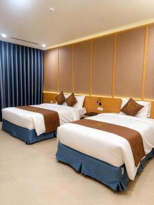 two beds in a hotel room with at Luxury 79 Hotel Hải Phòng in Hai Phong