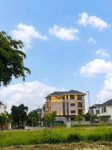 a building in the middle of a field with houses at Luxury 79 Hotel Hải Phòng in Hai Phong