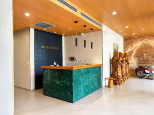 a lobby with a green counter in a museum at Luxury 79 Hotel Hải Phòng in Hai Phong