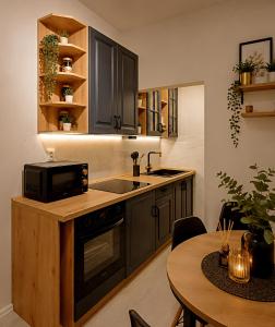 a kitchen with a sink and a microwave and a table at Casa de Flores in Knjazevac. +3 photos
