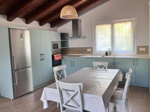 a kitchen with a table with chairs and a refrigerator at Altxerri Baserria in Aia