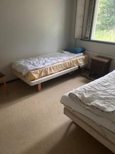 two beds sitting in a room with a window at Rivitalo 2 in Loimaa