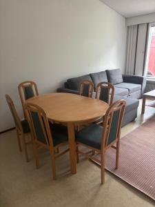 a table and chairs in a living room with a couch at Rivitalo 2 in Loimaa