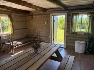 a wooden cabin with a wooden table and a bed at Heinaküün - magamine heinalakas in Pärna