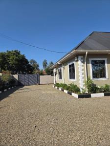 a house with a gravel driveway in front of it at Boma Retreat in Boma la Ngombe