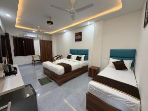 a hotel room with two beds and a desk at Hotel V Stay in Chennai +51 photos