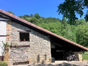a stone building with two bikes parked in it at Altxerri Baserria in Aia +7 photos