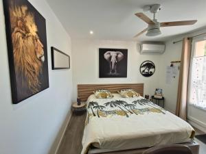 a bedroom with a bed and pictures on the wall at " LE CHABASSOLE " CHAMBRES D'HÔTES - GORGES du VERDON in Aiguines