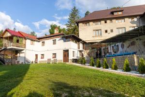 a large building with a yard in front of it at Casa SEMA in Sinaia