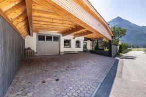 a house with a wooden roof and a garage at LIDA CHALET in Längenfeld