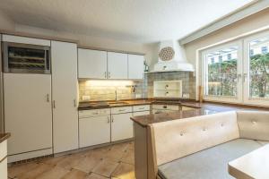 a kitchen with white cabinets and a large window at LIDA CHALET in Längenfeld +61 photos