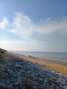 a beach with rocks and the ocean on a cloudy day at Domaine jard mer in Jard-sur-Mer +2 photos