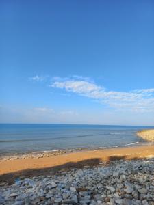 a beach with rocks and the ocean on a sunny day at Domaine jard mer in Jard-sur-Mer