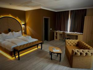 a hotel room with a bed and a couch at Hotel Zouk Suite Spa in Alba Iulia