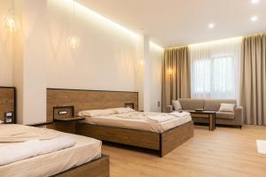 a hotel room with two beds and a couch at Ambra & Arber Hotel in Bogovë