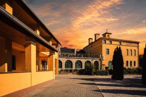 a building with a sunset in the background at Hotel Cabernet in Villánykövesd