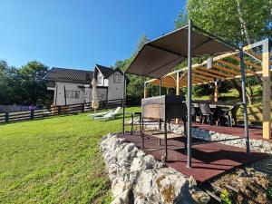 a pavilion with a table and chairs in a yard at Casa Sofisa in Fundata