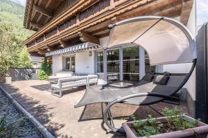a patio with two benches and a building at LIDA CHALET in Längenfeld