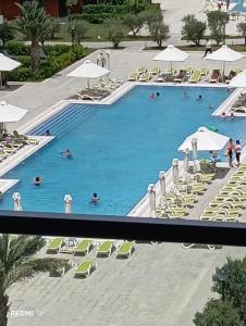 a large swimming pool with chairs and umbrellas at Sea Breeze Vibe in Nardaran