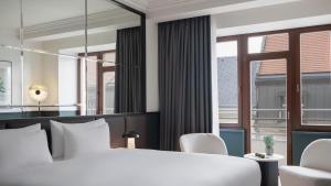 ein Schlafzimmer mit einem weißen Bett und einem großen Fenster in der Unterkunft Almanac X Alcron Prague in Prag