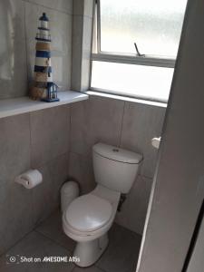 a small bathroom with a toilet and a window at 1 Seabreeze Cottage in Durban