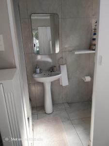 a bathroom with a sink and a mirror at 1 Seabreeze Cottage in Durban