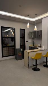 a kitchen with two yellow chairs and a counter at شاليه in Al Baha