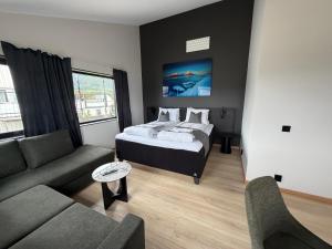a bedroom with a bed and a living room with a couch at Hotell Sjyen in Nesna