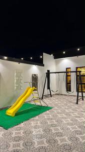 a playground with a yellow slide in a room at شاليه in Al Baha