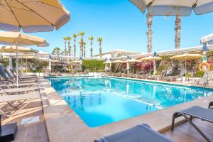 a pool at a resort with chairs and umbrellas at THB Gran Playa - Adults Only in Can Picafort