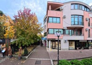 a pink building with a street light in front of it at Apartman Lili in Vrnjačka Banja