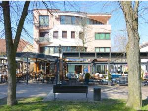 a park bench in front of a building with tables and chairs at Apartman Lili in Vrnjačka Banja
