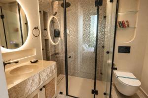 a bathroom with a shower and a toilet and a sink at Inanna Resort in Kifrayyā